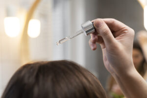 young-woman-applying-anti-dandruff-product-scaled.jpg